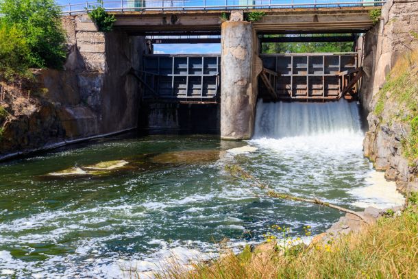 Flowing water with water spray from the open sluice gates of a s